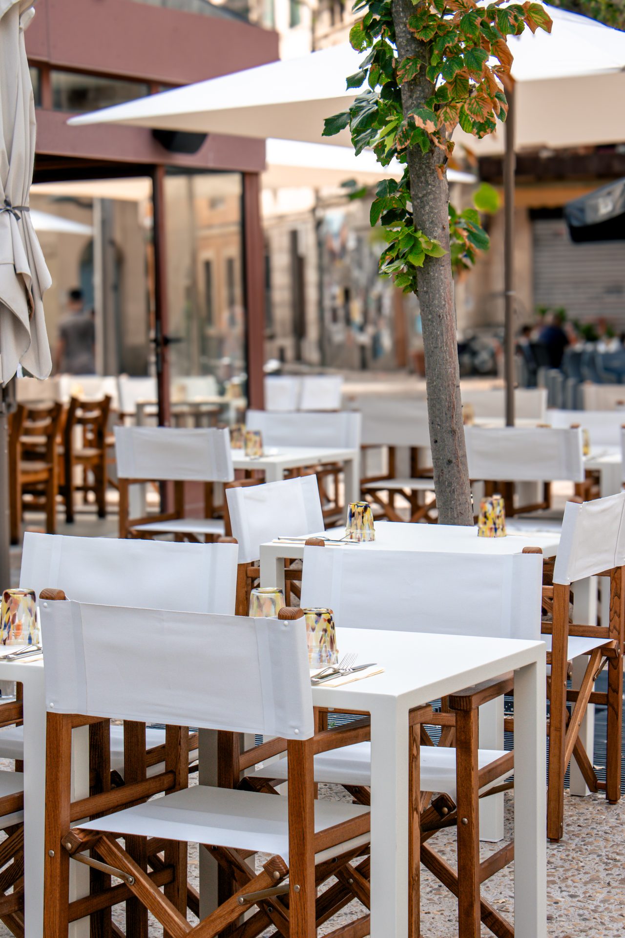 Terrasse ombragée de l'Hôtel Voltaire, tables et fauteuils metteur en scène